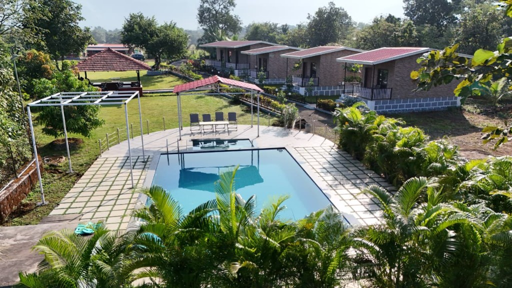 Ariyo Farmstay â€” aerial view of pool and stone cottages